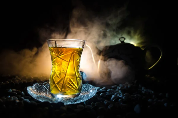 Té turco de Azerbaiyán en vidrio tradicional y olla sobre fondo negro con luces y humo. Copa tradicional Armudu —  Fotos de Stock