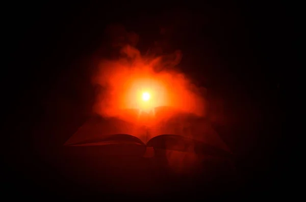 Libro aperto vicino lampada da tavolo incandescente su sfondo scuro, Lampada e libro aperto con fumo su sfondo. Surreale — Foto Stock