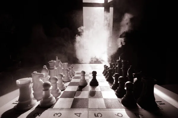 Conceito de jogo de tabuleiro de xadrez de ideias de negócios e concorrência e ideias de estratégia concep. Figuras de xadrez em um fundo escuro com fumaça e nevoeiro. Foco seletivo. Mão coloca figura a bordo — Fotografia de Stock