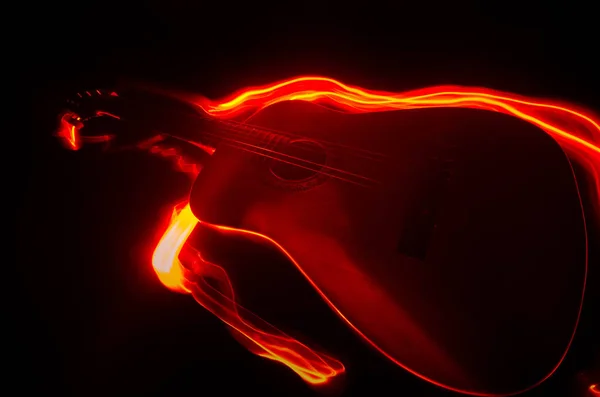 Conceito musical. Guitarra acústica isolada em fundo escuro sob feixe de luz com fumaça com espaço de cópia. Cordas de guitarra, de perto. Foco seletivo. Efeitos de fogo — Fotografia de Stock