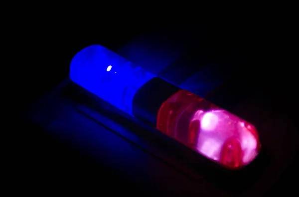 Un feu rouge clignote au sommet d'une voiture de police. Lumières de ville sur le fond. Concept de gouvernement policier — Photo