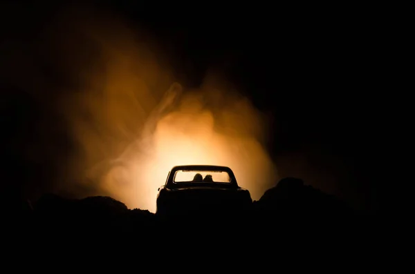 Silueta vozu s pár uvnitř na tmavém pozadí se světly a kouř. Romantickou scénu. Láska koncept — Stock fotografie