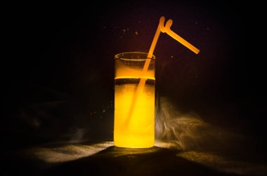 Kireç ile süslenmiş parlak sarı yeşil kokteyl. Klasik alkol kokteyller, alkolsüz içecekler, alkolsüz içecekler, duman ve ışık ile karanlık arka plan üzerinde lezzetli kokteyller