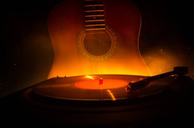 Arka plan ateş portakal duman ile oyuncu ve akustik gitarda oynamak vintage vinil kaydı. Blues kavramı.