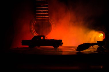 Arka plan ateş portakal duman ile oyuncu ve akustik gitarda oynamak vintage vinil kaydı. Blues kavramı.