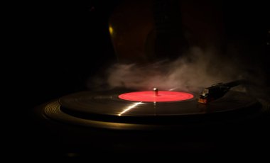 Arka plan ateş portakal duman ile oyuncu ve akustik gitarda oynamak vintage vinil kaydı. Blues kavramı.