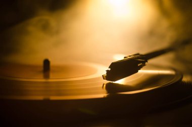 Pikap vinil plak çalar. Retro ses ekipmanları için disk jokey. Dj mix ve müzik çalmak için ses teknolojisi. Yangın arka plan duman ile yanan karşı oynanan vinil kaydı. Vintage