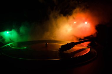 Pikap vinil plak çalar. Retro ses ekipmanları için disk jokey. Dj mix ve müzik çalmak için ses teknolojisi. Yangın arka plan duman ile yanan karşı oynanan vinil kaydı. Vintage