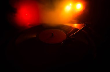 Pikap vinil plak çalar. Retro ses ekipmanları için disk jokey. Dj mix ve müzik çalmak için ses teknolojisi. Yangın arka plan duman ile yanan karşı oynanan vinil kaydı. Vintage