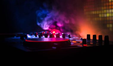 DJ iplik, karıştırma ve bir gece kulübünde tırmalamak, eller DJ 's dj güverte, strobe ışıklar ve sis, seçici odak çeşitli parça denetimlere tweak