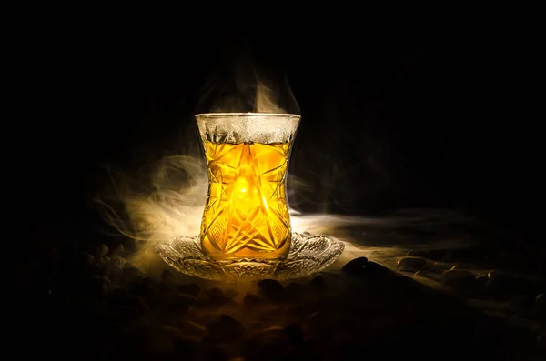 Té turco de Azerbaiyán en vidrio tradicional y olla sobre fondo negro con luces y humo. Copa tradicional Armudu — Foto de Stock