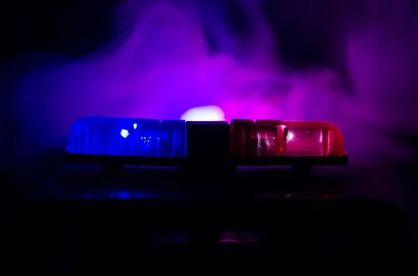La luz roja parpadea sobre un coche de policía. Luces de la ciudad al fondo. Concepto de gobierno policial —  Fotos de Stock