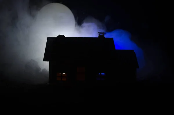 Old house with a Ghost in the moonlit night or Abandoned Haunted Horror House in fog, Old mystic villa with surreal big full moon. Horror concept