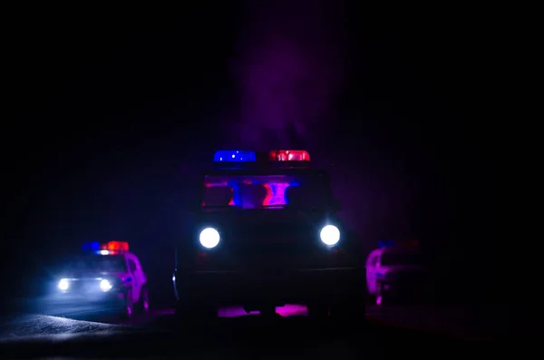 Geschwindigkeitsbeleuchtung von Polizeiwagen in der Nacht auf der Straße. Polizeiautos im Nebel unterwegs. Selektiver Fokus. Verfolgungsjagd — Stockfoto