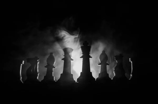 Chess brädspel begreppet affärsidéer och konkurrens och strategi idéer begreppsmässigt. Chess siffror på en mörk bakgrund med rök och dimma — Stockfoto