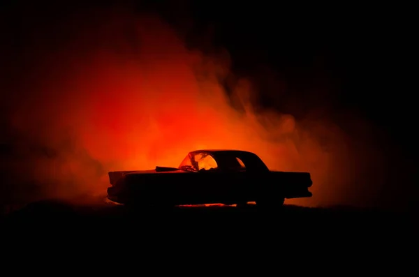 Carro a arder num fundo escuro. Carro pegando fogo, após ato de vandalismo ou estrada indicativo — Fotografia de Stock