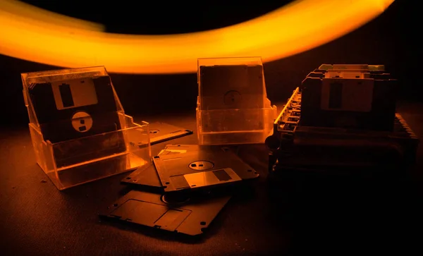 Mucchio di floppy disk neri su sfondo scuro con luce. Attributi per computer vintage — Foto Stock