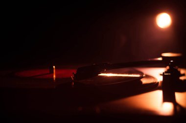 Pikap vinil plak çalar. Retro ses ekipmanları için disk jokey. Dj mix ve müzik çalmak için ses teknolojisi. Yangın arka plan duman ile yanan karşı oynanan vinil kaydı. Vintage