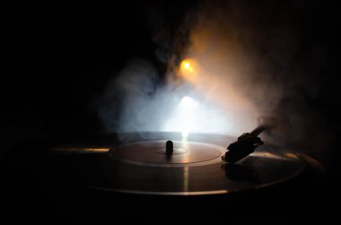 Pikap vinil plak çalar. Retro ses ekipmanları için disk jokey. Dj mix ve müzik çalmak için ses teknolojisi. Yangın arka plan duman ile yanan karşı oynanan vinil kaydı. Vintage