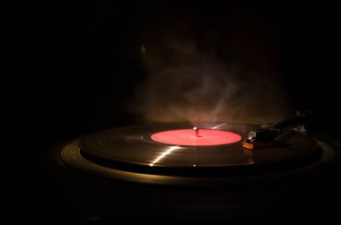 Arka plan ateş portakal duman ile oyuncu ve akustik gitarda oynamak vintage vinil kaydı. Blues kavramı.