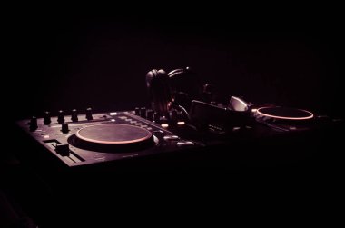 DJ iplik, karıştırma ve bir gece kulübünde tırmalamak, eller DJ 's dj güverte, strobe ışıklar ve sis, seçici odak çeşitli parça denetimlere tweak
