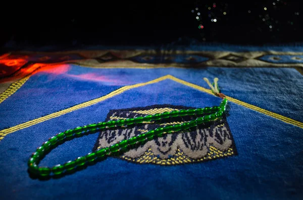 Holy Quran with beads on a prayer mat, Muslim Tasbih is a string of prayer beads which is traditionally used by Muslims along with the Quran. Ramadan holidays concept — Stock Photo, Image