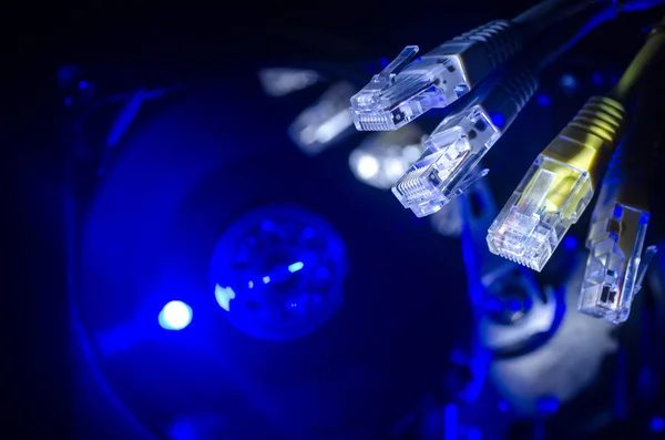 Сетевой коммутатор и Ethernet кабели, символ глобальных коммуникаций. Цветные сетевые кабели на тёмном фоне с огнями и дымом. Селективный фокус — стоковое фото