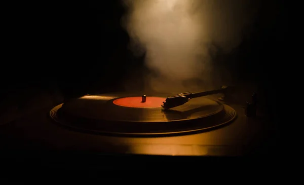 Tocador de vinilo giratorio. Equipo de audio retro para disc jockey. Tecnología de sonido para DJ para mezclar y reproducir música. Grabación de vinilo que se reproduce contra el fuego ardiente de fondo con humo. Vintage — Foto de Stock