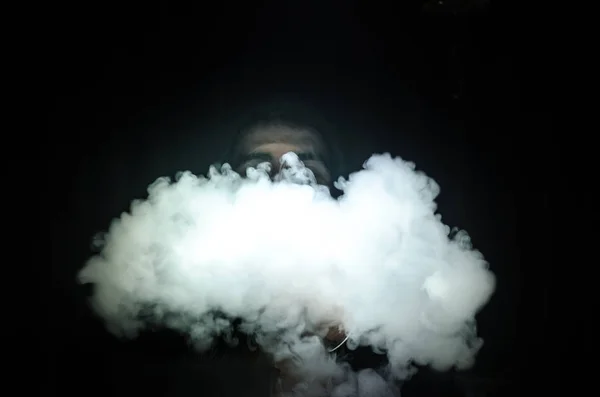 Vaping 남자 모드를 들고입니다. 증기의 구름입니다. 검은 배경. Vaping 연기의 많은 전자 담배 — 스톡 사진