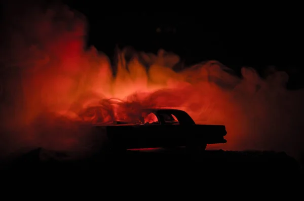 Carro a arder num fundo escuro. Carro pegando fogo, após ato de vandalismo ou estrada indicativo — Fotografia de Stock