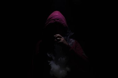 Bir mod tutarak Vaping adam. Buhar bulutu. Siyah arka plan. Vaping çok duman ile elektronik sigara