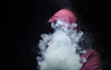 Bir mod tutarak Vaping adam. Buhar bulutu. Siyah arka plan. Vaping çok duman ile elektronik sigara