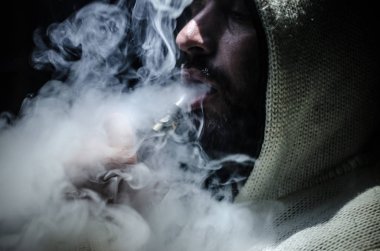 Bir mod tutarak Vaping adam. Buhar bulutu. Siyah arka plan. Vaping çok duman ile elektronik sigara