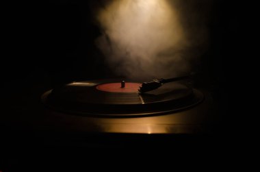 Pikap vinil plak çalar. Retro ses ekipmanları için disk jokey. Dj mix ve müzik çalmak için ses teknolojisi. Yangın arka plan duman ile yanan karşı oynanan vinil kaydı. Vintage