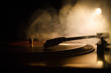 Pikap vinil plak çalar. Retro ses ekipmanları için disk jokey. Dj mix ve müzik çalmak için ses teknolojisi. Yangın arka plan duman ile yanan karşı oynanan vinil kaydı. Vintage