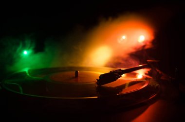 Pikap vinil plak çalar. Retro ses ekipmanları için disk jokey. Dj mix ve müzik çalmak için ses teknolojisi. Yangın arka plan duman ile yanan karşı oynanan vinil kaydı. Vintage