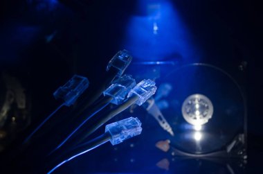 Ağ anahtarı ve ethernet kabloları, global iletişim sembolüdür. Işıklar ve duman ile koyu arka plan üzerinde renkli ağ kabloları. Seçici odak