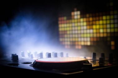 DJ iplik, karıştırma ve bir gece kulübünde tırmalamak, eller DJ 's dj güverte, strobe ışıklar ve sis, seçici odak çeşitli parça denetimlere tweak