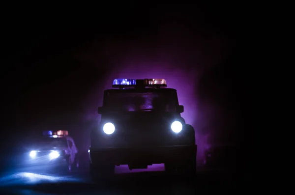 Geschwindigkeitsbeleuchtung von Polizeiwagen in der Nacht auf der Straße. Polizeiautos im Nebel unterwegs. Selektiver Fokus. Verfolgungsjagd — Stockfoto