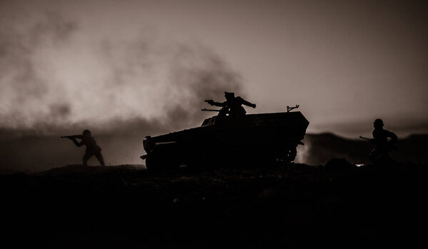 War Concept. Military silhouettes fighting scene on war fog sky background, World War Soldiers Silhouettes Below Cloudy Skyline At sunset. Attack scene. German tank in action