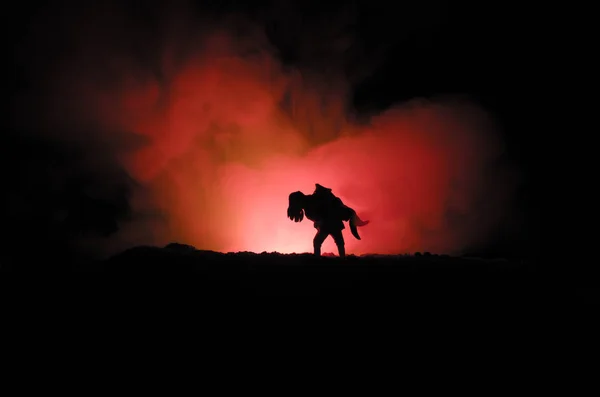 Uma silhueta de um homem agarrado à mulher. Conceito de salvamento de salvamento. Fuja do fogo ou do perigo. Ampulheta, Fogo — Fotografia de Stock