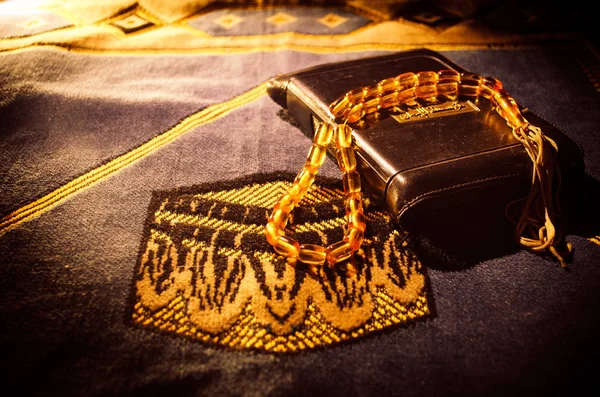 Sacro Corano con perline su un tappeto di preghiera, Muslim Tasbih è una stringa di perline di preghiera che viene tradizionalmente utilizzata dai musulmani insieme al Corano. Concetto vacanze Ramadan — Foto Stock