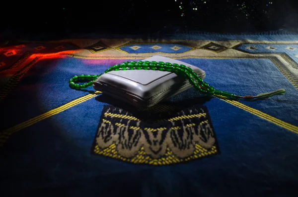 Alcorão Sagrado com missangas em um tapete de oração, Tasbih Muçulmano é uma série de missangas de oração que é tradicionalmente usado pelos muçulmanos, juntamente com o Alcorão. Conceito feriados Ramadã — Fotografia de Stock