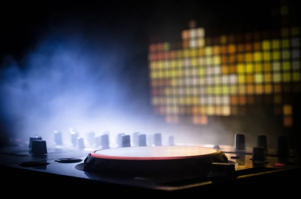 DJ spinnen, mixen en scratchen in een nachtclub, handen van dj tweak verschillende track besturingselementen op dj's dek, strobe lights en mist, selectieve aandacht — Stockfoto