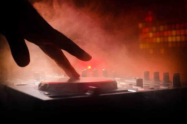 DJ Spinning, Mixing e Scratching in a Night Club, Hands of dj tweak vari controlli di pista sul ponte del DJ, luci stroboscopiche e nebbia, messa a fuoco selettiva — Foto Stock