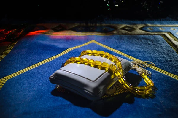 Sagrado Corán con cuentas en una alfombra de oración, Muslim Tasbih es una cadena de cuentas de oración que tradicionalmente utilizan los musulmanes junto con el Corán. Concepto de vacaciones Ramadán — Foto de Stock