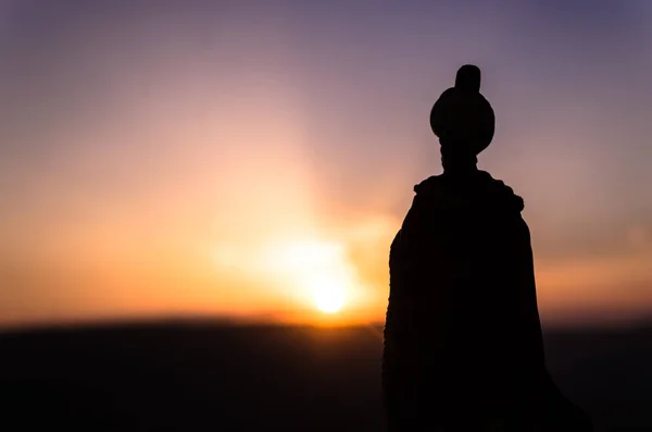 Silhouette des arabischen Mannes steht allein in der Wüste und beobachtet den Sonnenuntergang mit Nebelschwaden. Östliches Märchen — Stockfoto