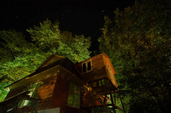 Krásná krajina Náves s budov a stromů a velký úplněk na noční oblohu. Velký Kavkaz . — Stock fotografie