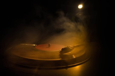 Pikap vinil plak çalar. Retro ses ekipmanları için disk jokey. Dj mix ve müzik çalmak için ses teknolojisi. Yangın arka plan duman ile yanan karşı oynanan vinil kaydı. Vintage