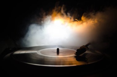 Pikap vinil plak çalar. Retro ses ekipmanları için disk jokey. Dj mix ve müzik çalmak için ses teknolojisi. Yangın arka plan duman ile yanan karşı oynanan vinil kaydı. Vintage